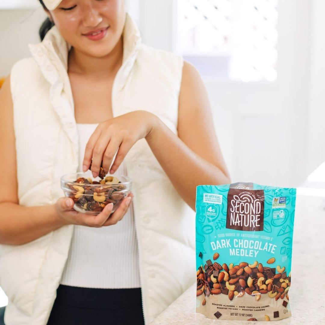 Lady grabbing Dark Chocolate Medley - 26 oz. from a glass bowl